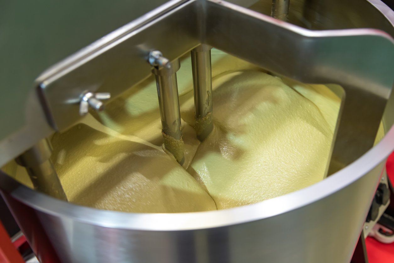 upclose mixer mixing yellow thick substance in tank