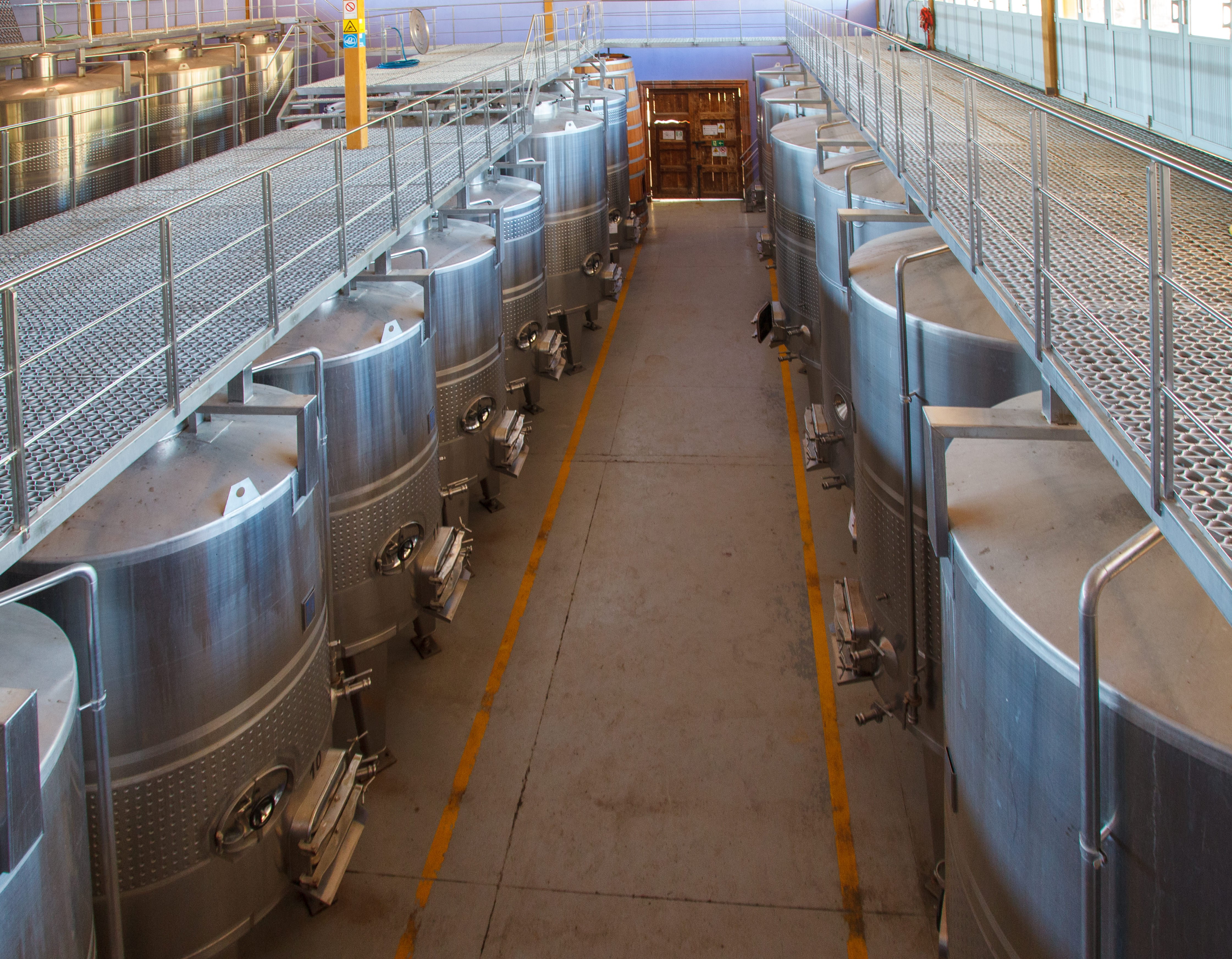 stainless steel tanks in a row within warehouse